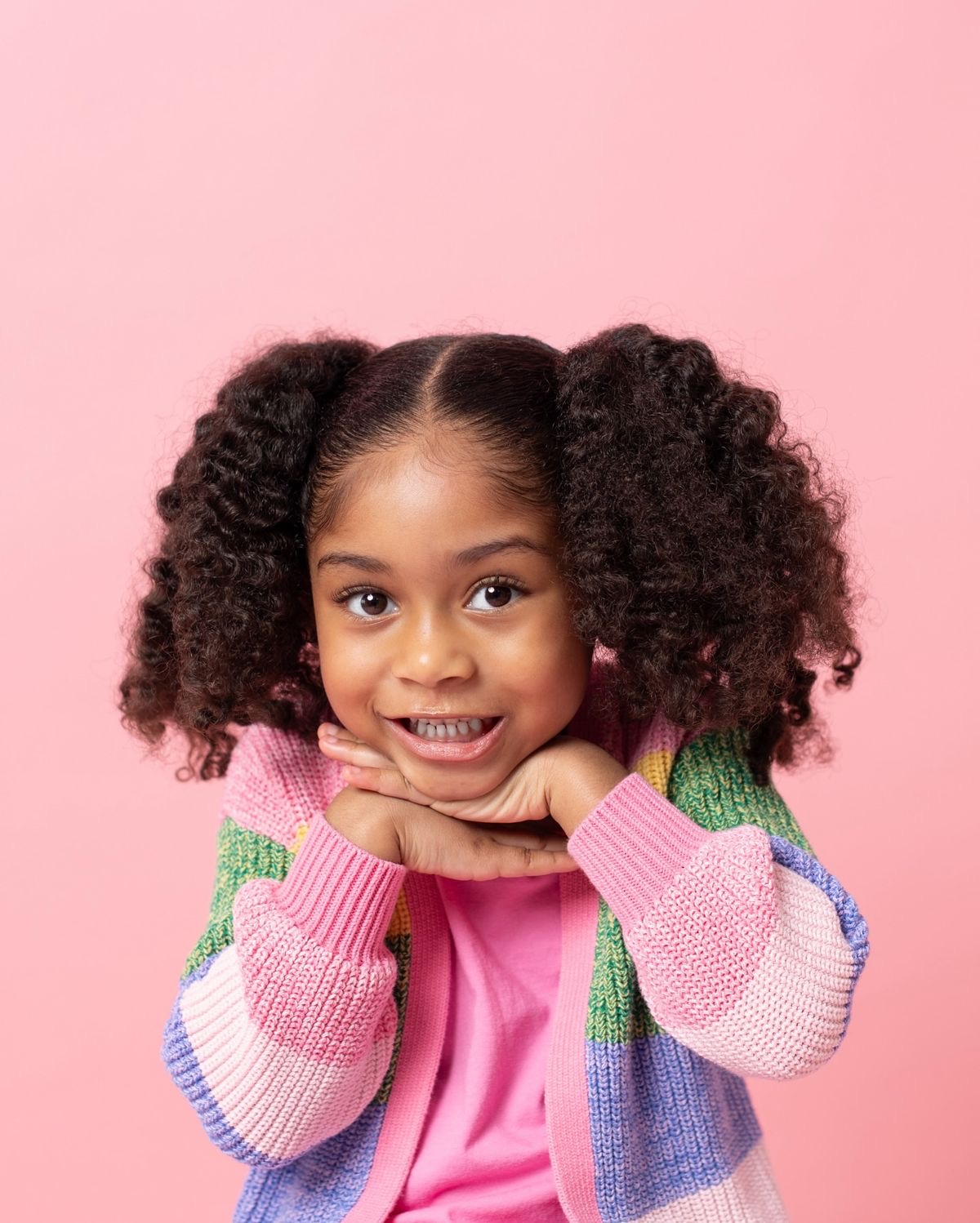 Enfant souriant sur fond rose