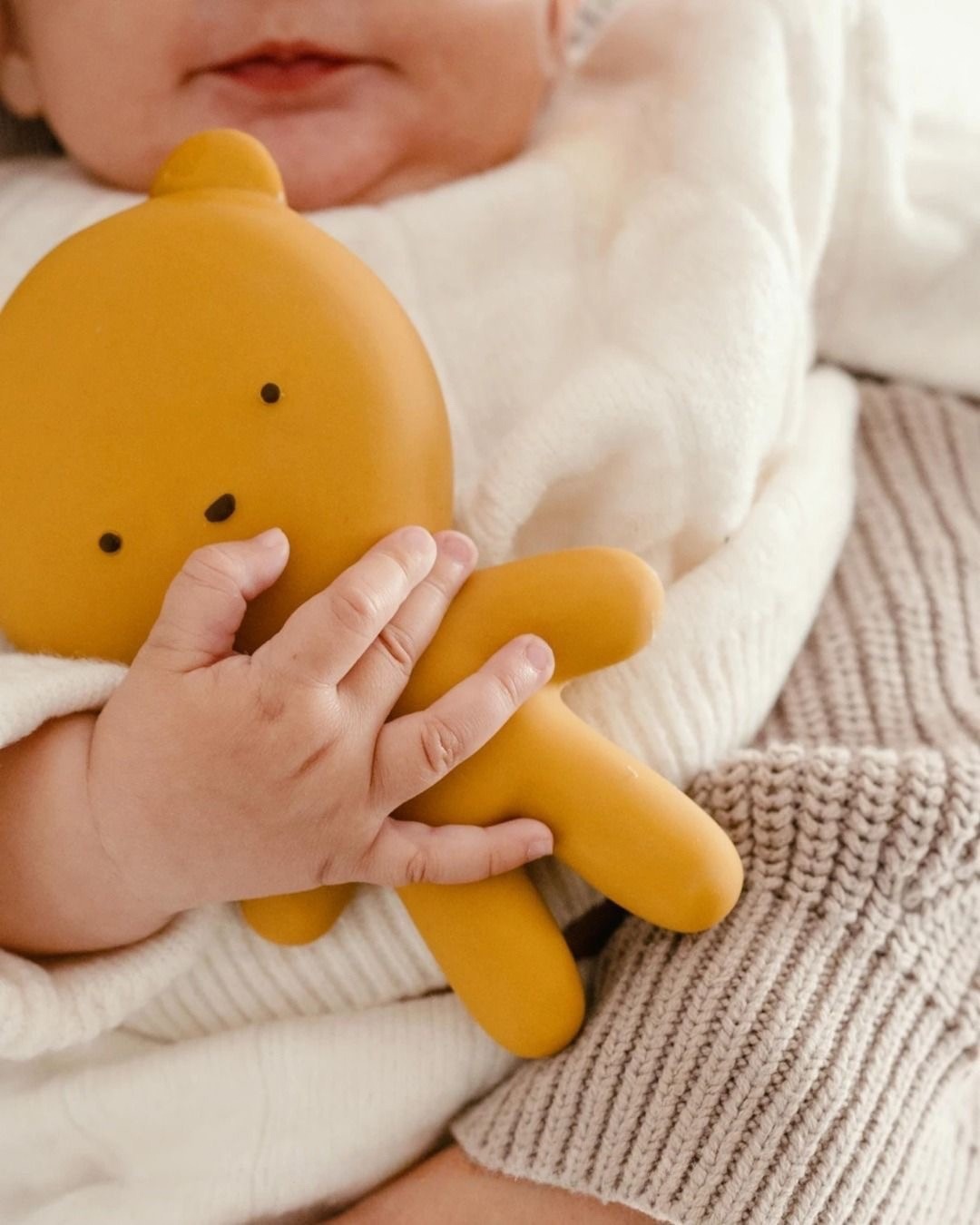 Bébé tenant un petit ours jaune