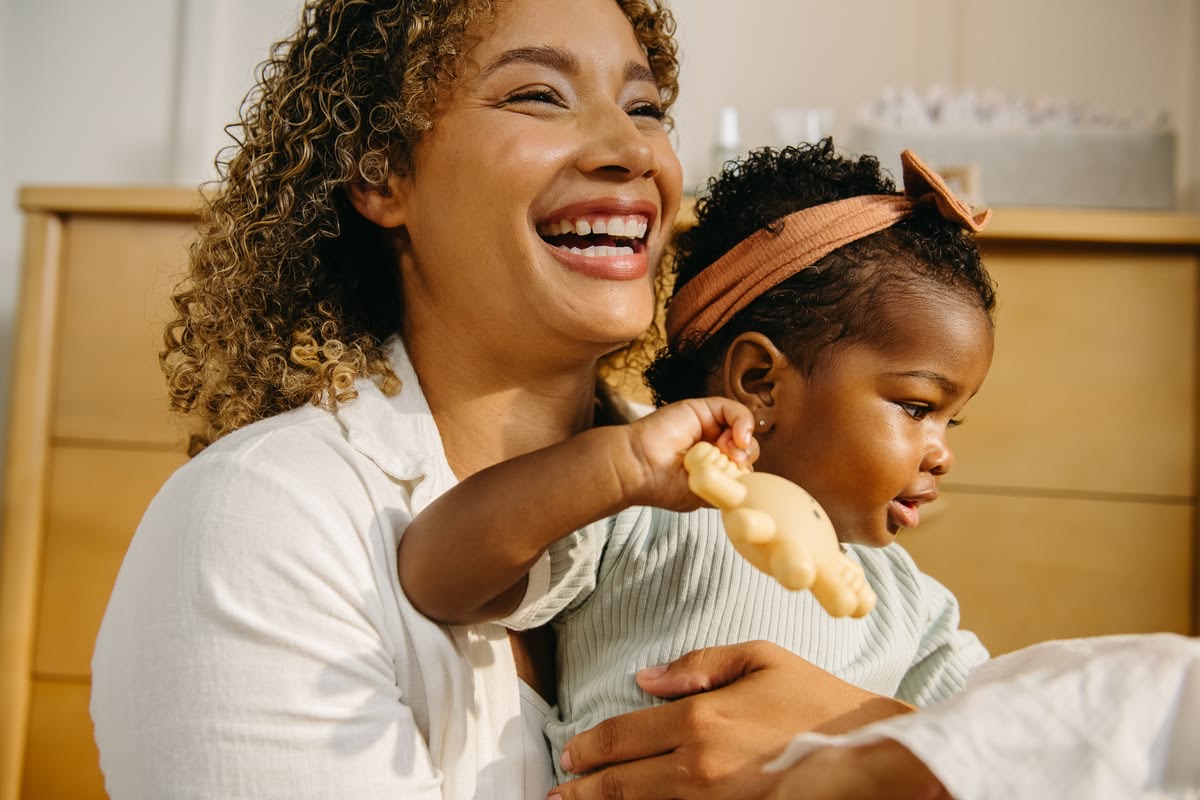 Une femme souriante tenant un jeune enfant